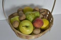 Basket with fruits and nuts on a white background.